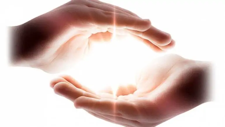 Mani che contengono un fascio di luce, come energia che si sprigiona con Reiki